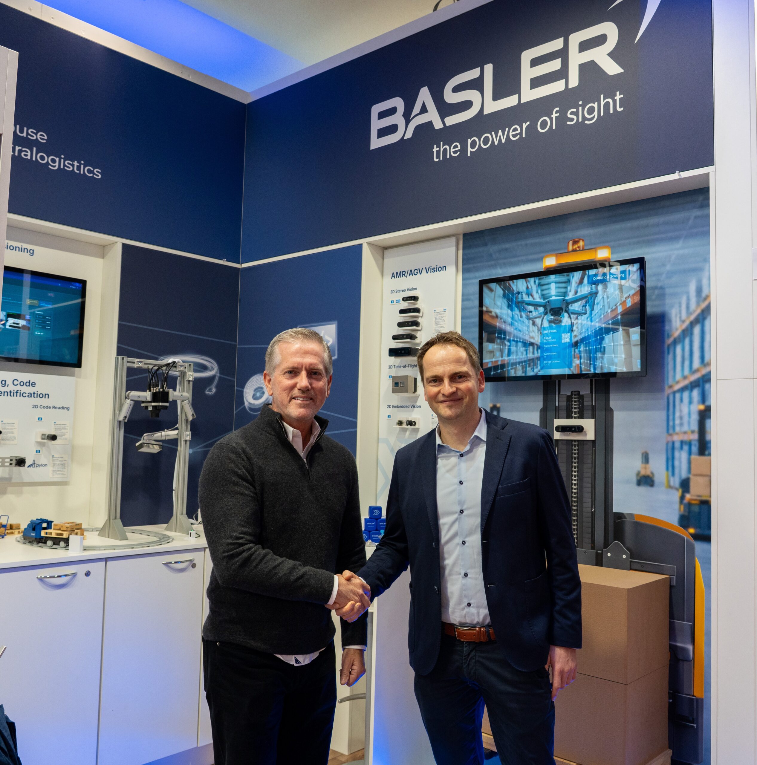Mike McSweeney, Vice President of Sales at Orbbec, and René von Fintel, Executive Director Business Management at Basler, shaking hands at the Basler booth during LogiMAT 2026